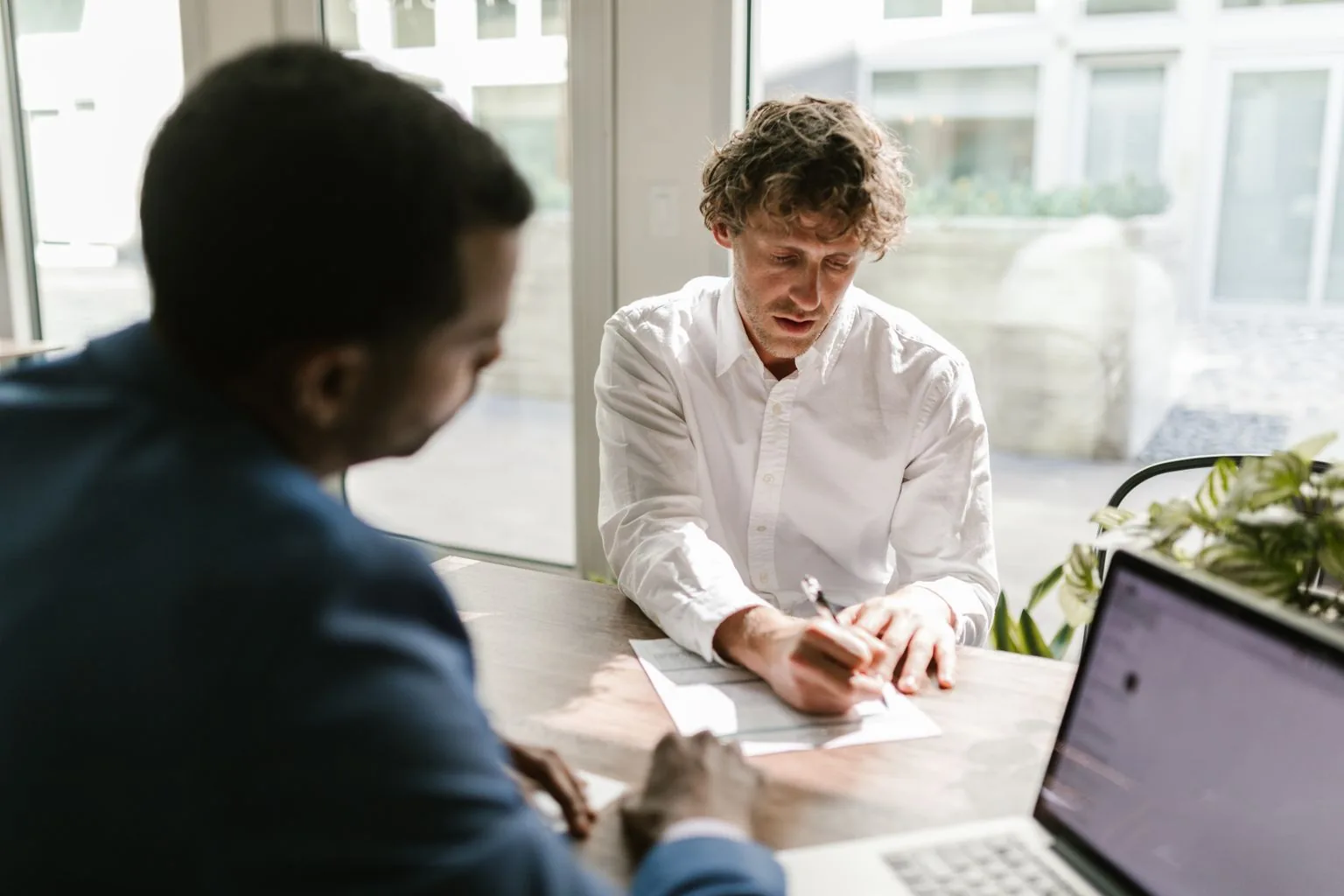 Professionnels relisant et signant un contrat dans un bureau